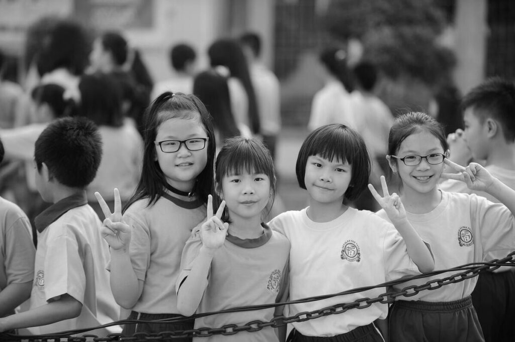 School girls displaying the victory sign.